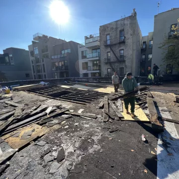 The_hardworking_laborers_of_The_Premiun_Roofing_were_diligently_shifting_wooden_sheets_to_the_roofing_site_to_ensure_the_structure_was_sturdy_and_secure_at_the_site_of_The_Premium_Roofing_in_114_Lexington_ave_Brooklyn_New_York_10016-8978
