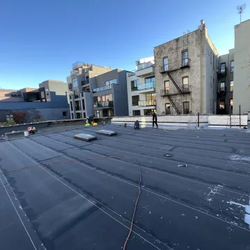 A_group_of_hardworking_laborers_of_The_Premiun_Roofing_efficiently_applying_coat_on_the_roof_in_Brooklyn_New_York
