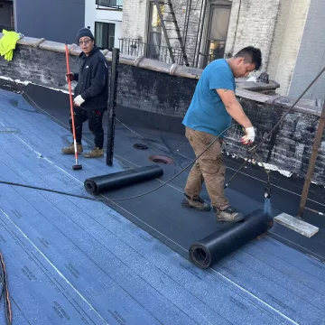 The_skilled_labourer_of_The_Premium_Roofing__carefully_rolled_on_the_coating_to_ensure_an_even_and_seamless_finish_on_the_roof_in_Brooklyn_New_York