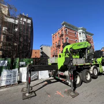 The_towering_crane_stood_majestically_in_front_of_the_bustling_roofing_site,_ready_to_hoist_and_place_each_beam_with_precision_at_the_site_of_The_Premium_Roofing_in_Brooklyn_New_York