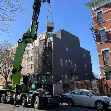 The_crane_was_carefully_lifting_the_materials_from_the_ground_floor_to_the_top_at_the_site_of_The_Premium_Roofing_in_Brooklyn_New_York